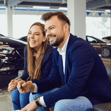 Glückliches Paar bespricht Kfz-Versicherungsoptionen bei autoversicherungsmakler.com Ein glückliches Paar diskutiert mögliche Kfz-Versicherungsoptionen mit professioneller Unterstützung durch Autoversicherungsmakler.com